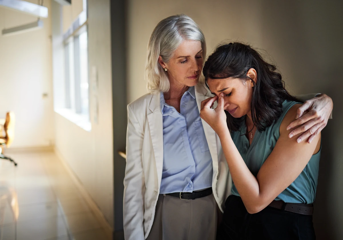 Une femme qui tient une autre qui pleure dans ses bras
